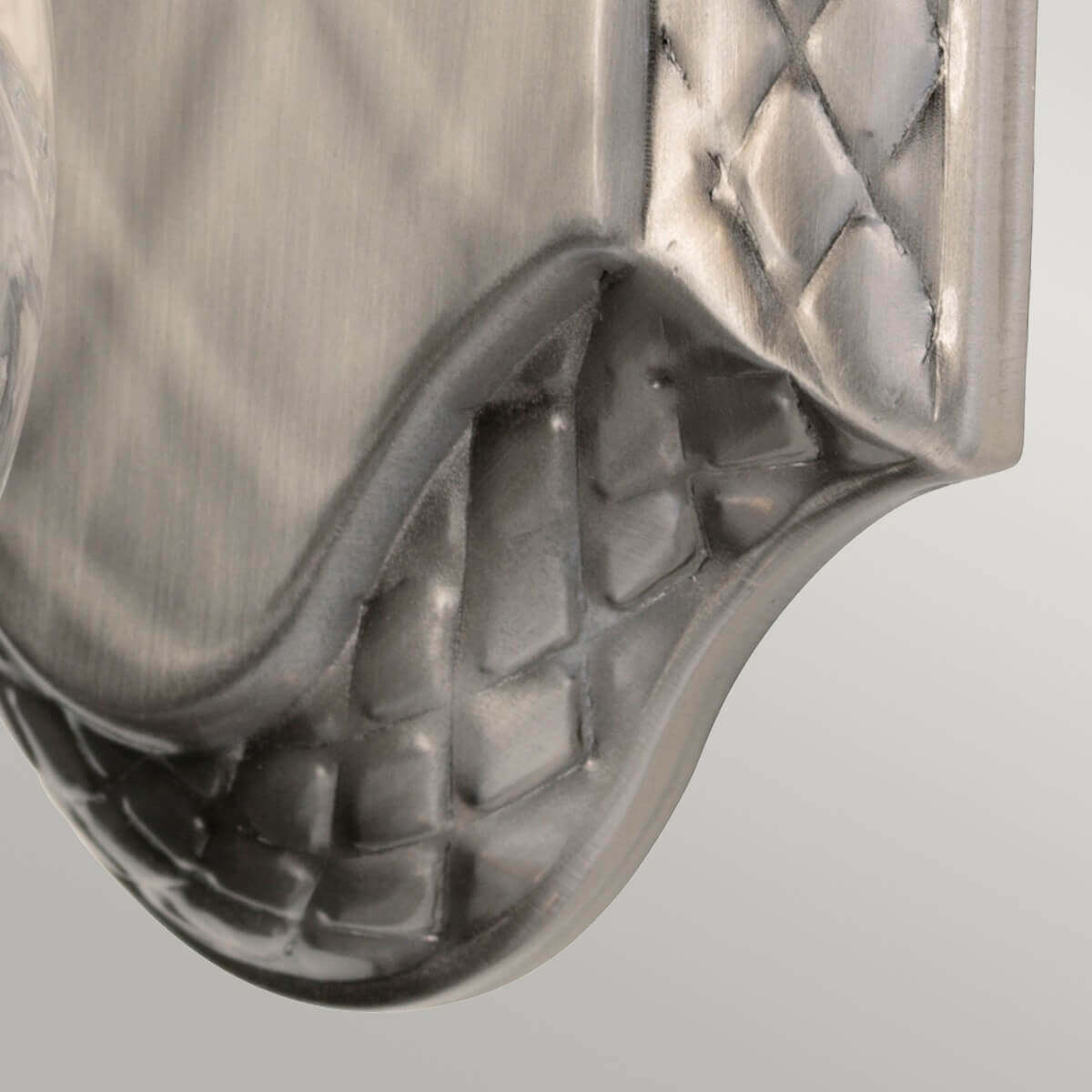 Détail de la platine murale avec motif tressé et finition nickel brossé
