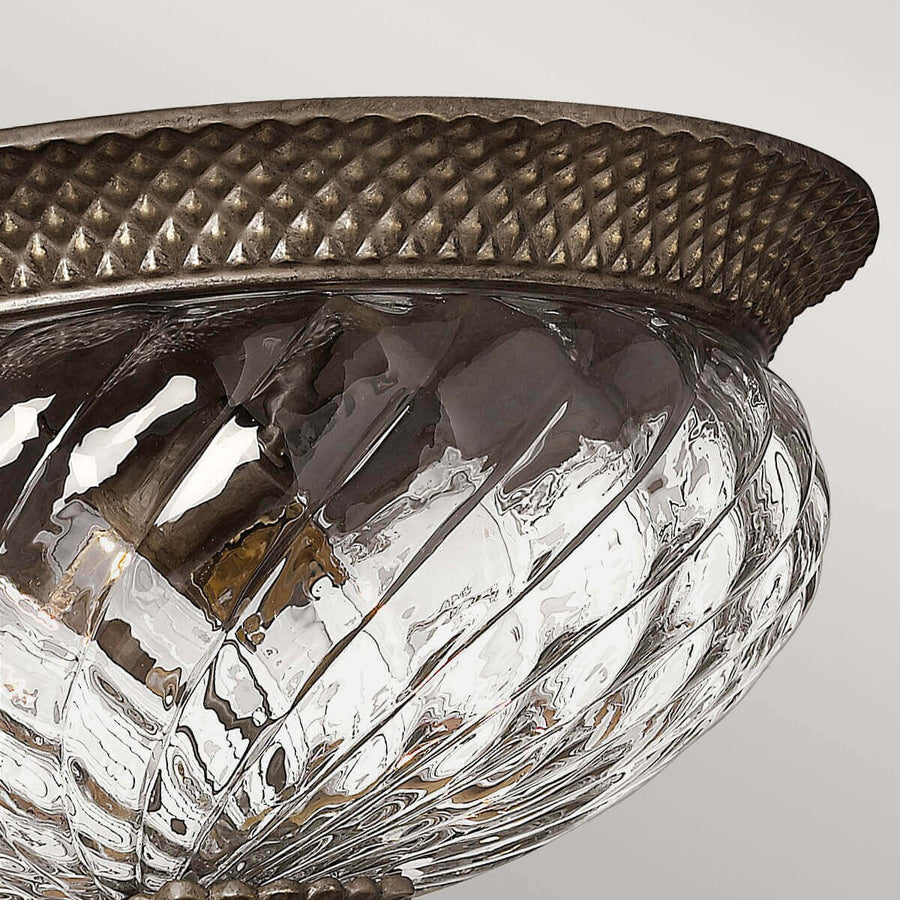 Détail rapproché de la bague en bronze au motif losangé et du verre strié