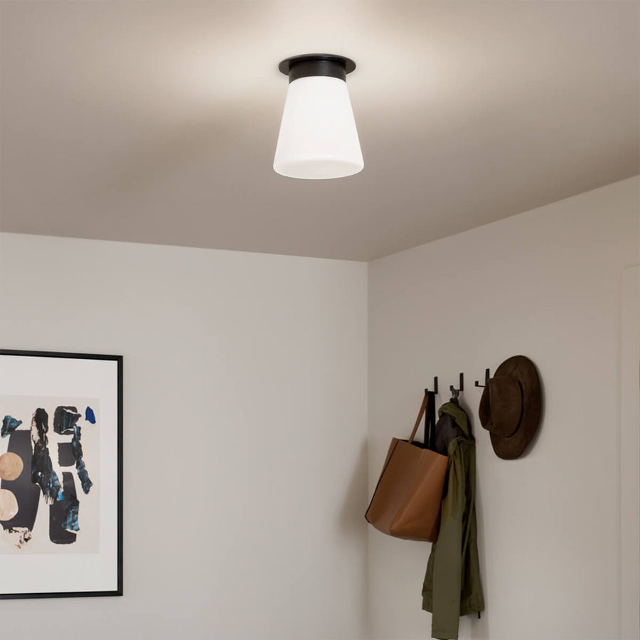 Plafonnier allumé au plafond d'une entrée, lumière diffusée douce