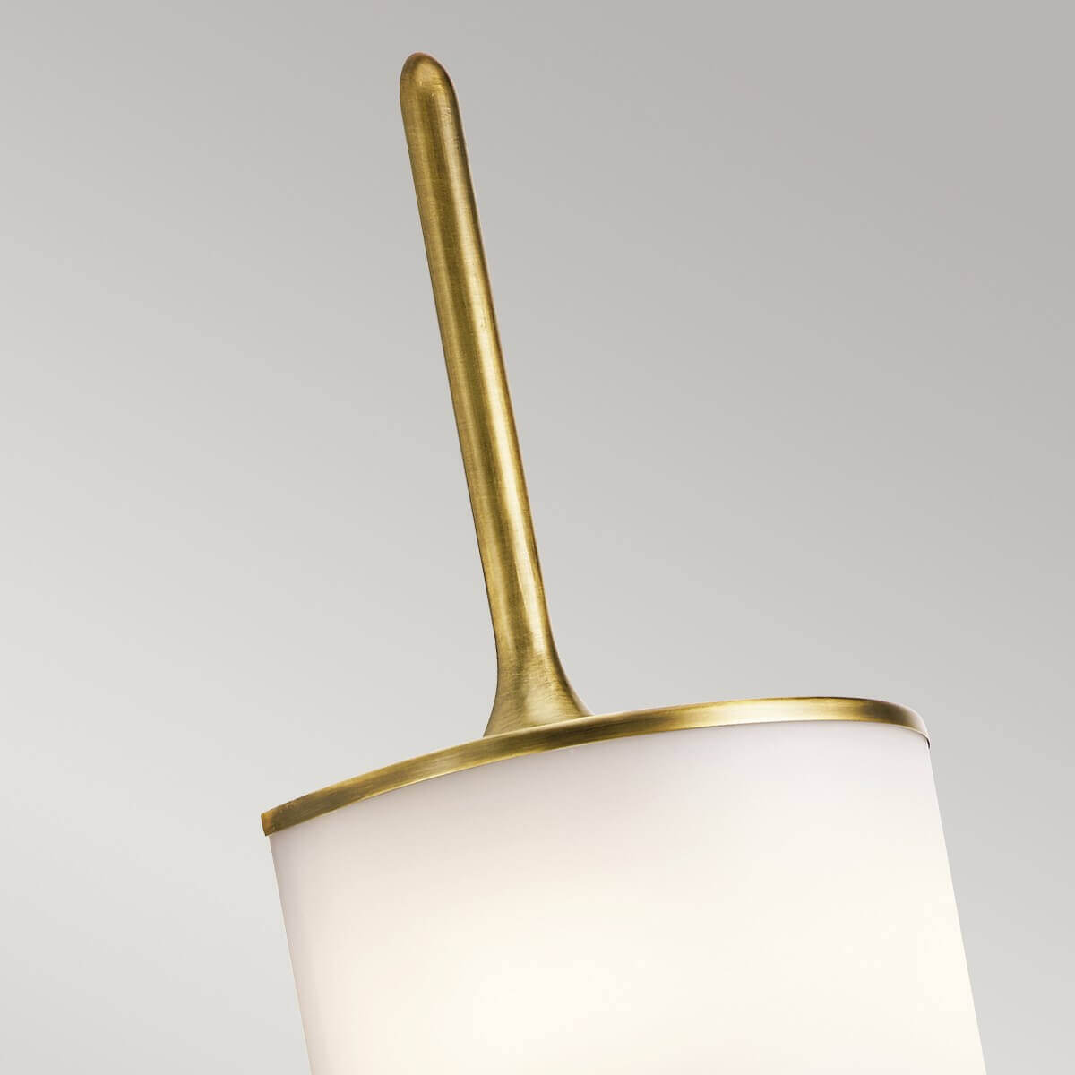 Détail du cylindre de verre blanc éclairé, encadré de deux fines bagues en laiton.