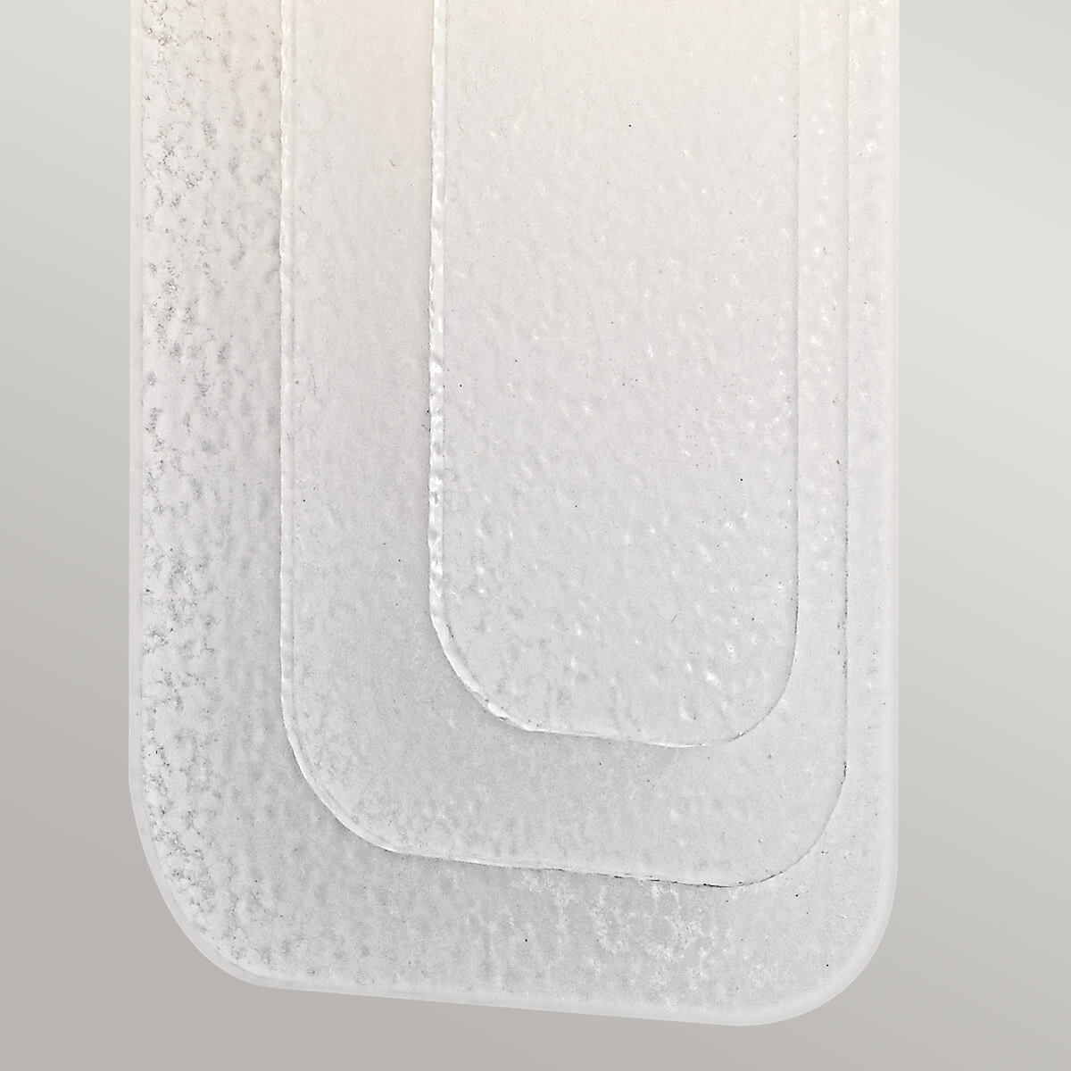 Détail du bas de la plaque de verre aux angles arrondis et granuleux