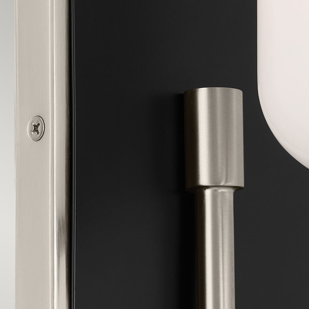Détail de la platine noire et vis visible, bras métallique en nickel satiné.