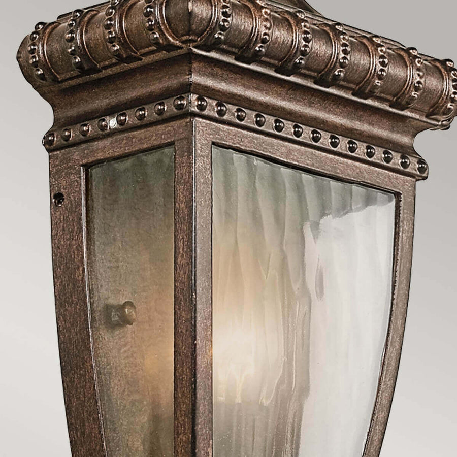 Gros plan sur l'angle supérieur, moulures perlées en bronze et verre strié