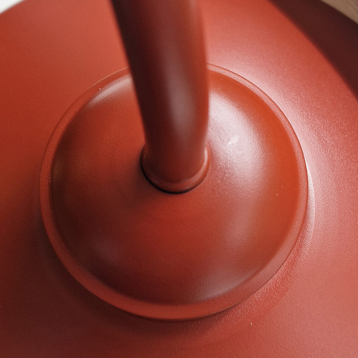 Détail rapproché de la platine et de l'embase du bras, finition rouge texturée