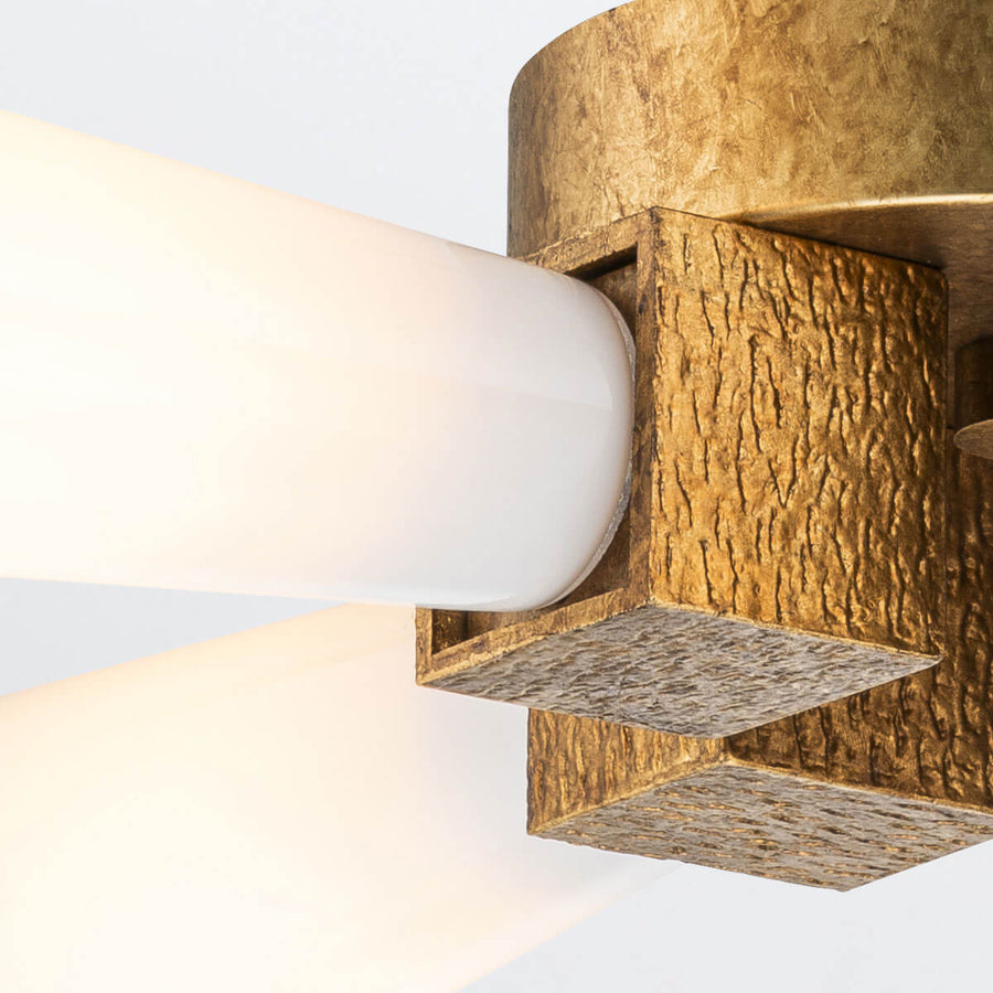 Gros plan sur un diffuseur cylindrique logé dans un support doré texturé