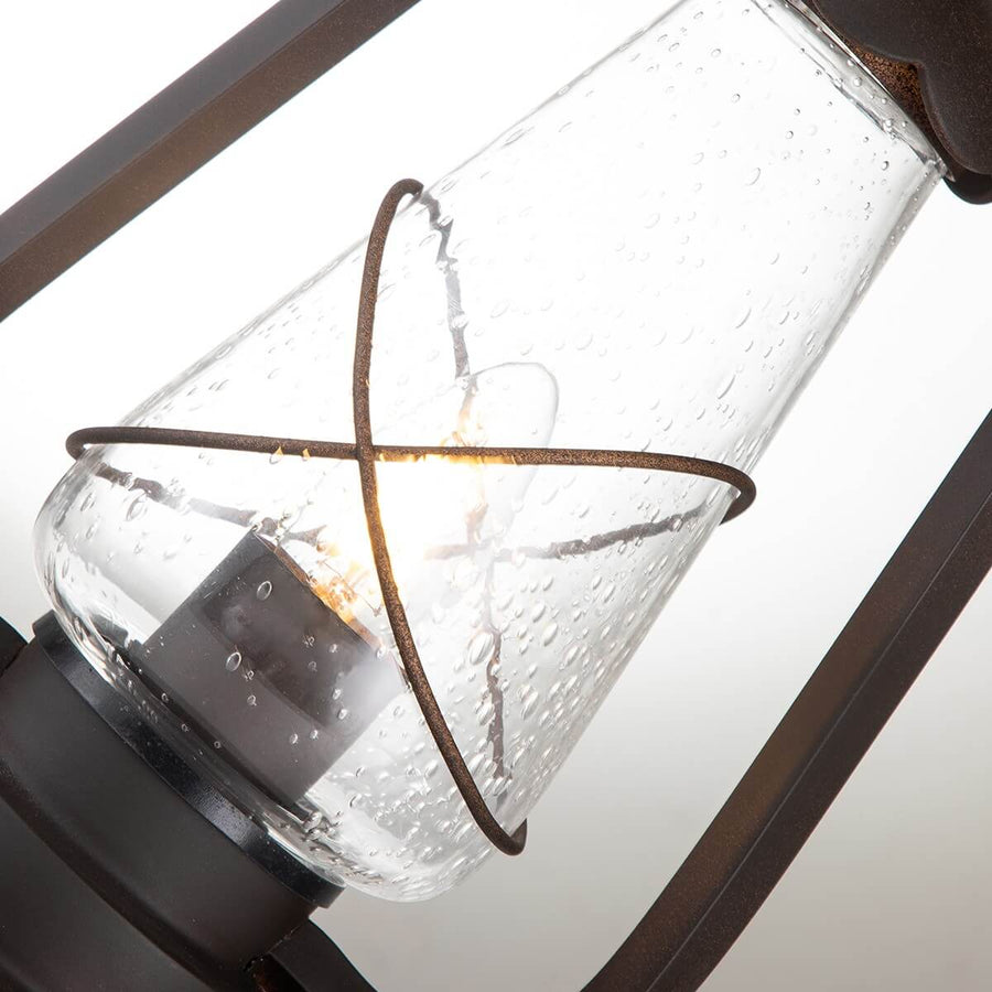 Gros plan sur le verre gouttelettes et l'ampoule à filament allumée