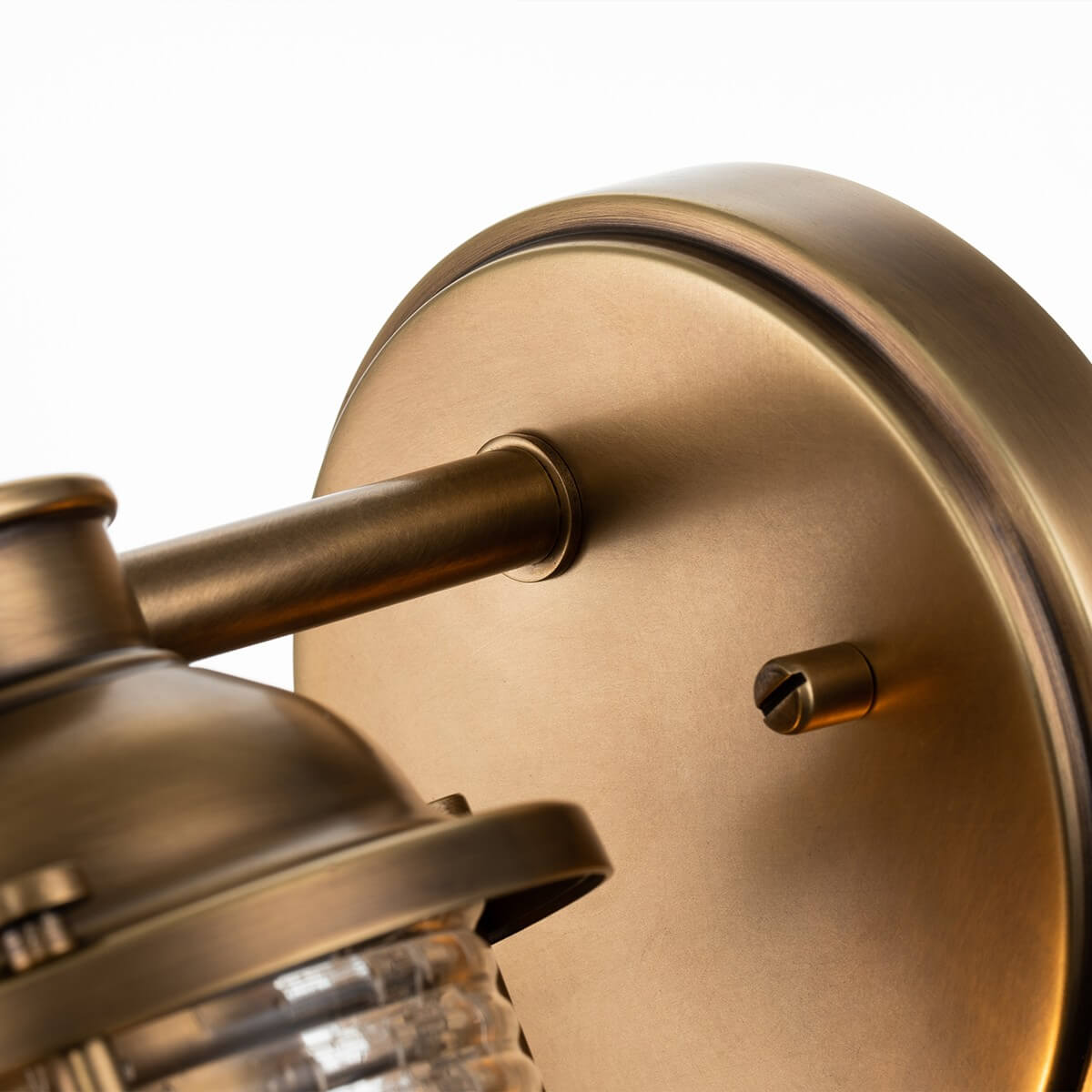 Détail de la platine ronde en métal brossé et de son support fixé au mur
