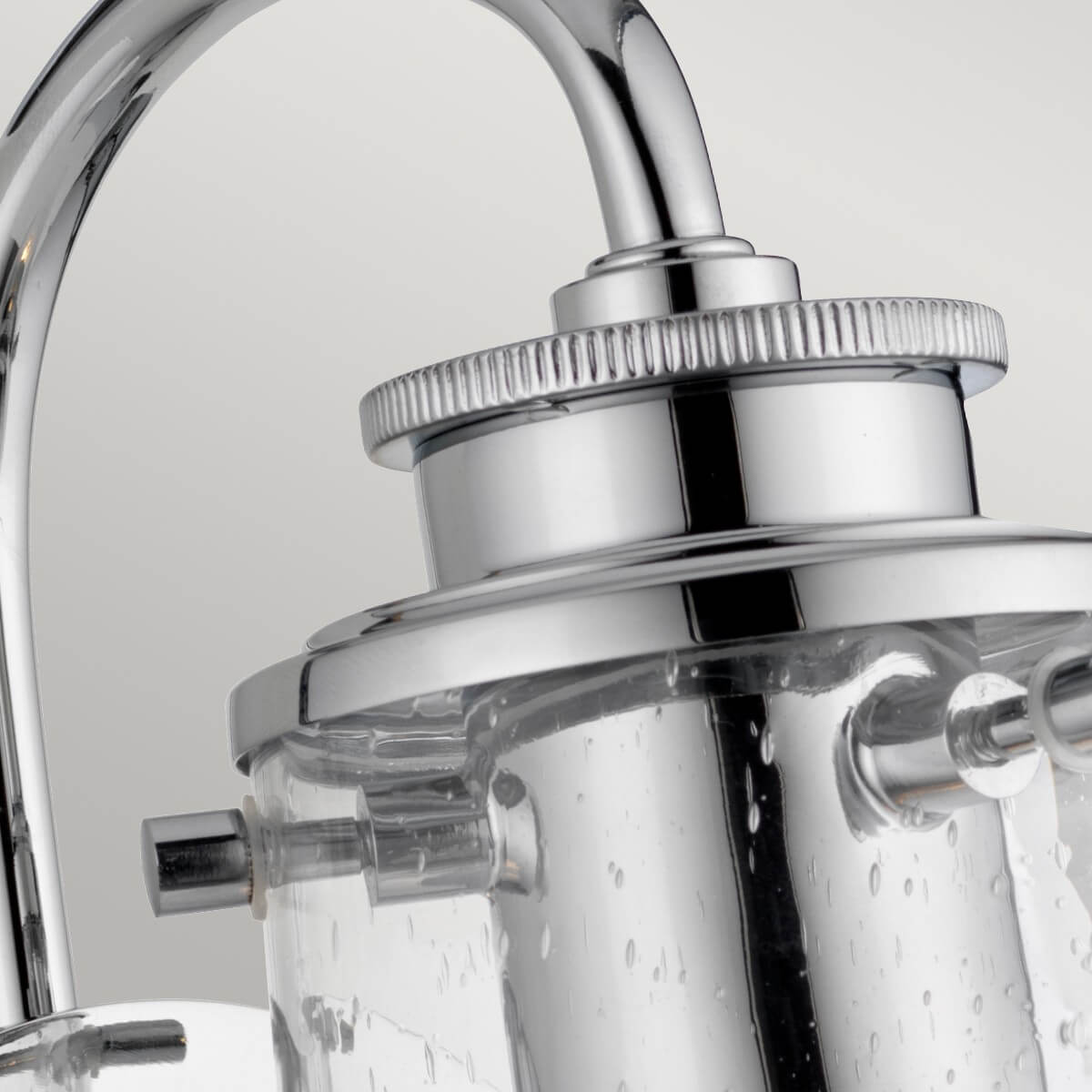 Détail du sommet chromé moleté et des vis maintenant le verre cylindrique