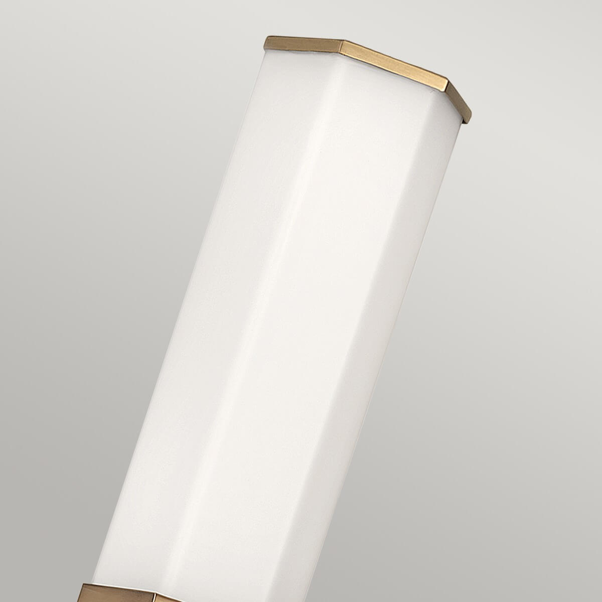 Détail du sommet : verre hexagonal blanc coiffé d'une fine collerette en laiton brossé