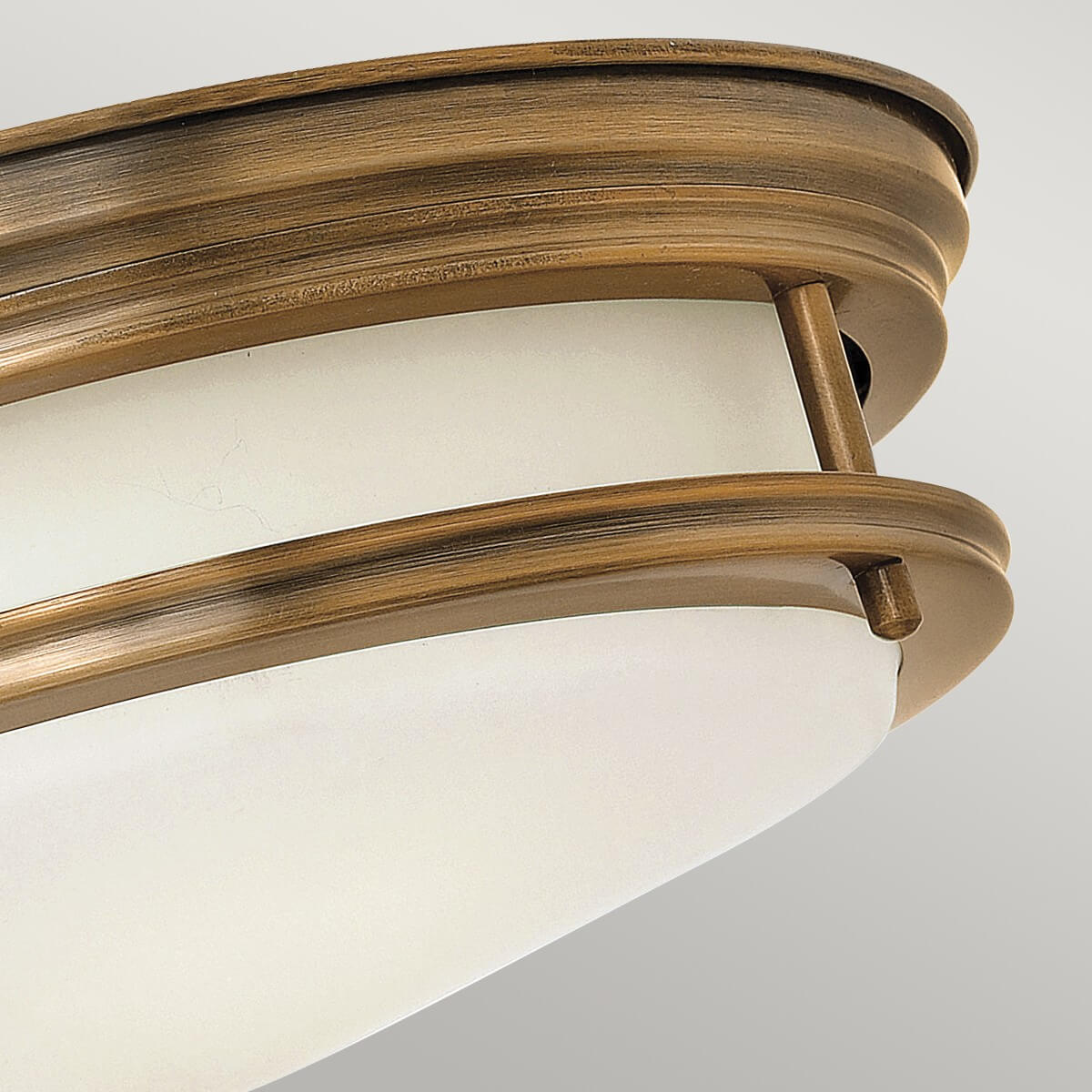 Détail de la finition bronze striée du bandeau et de la courbure du verre dépoli