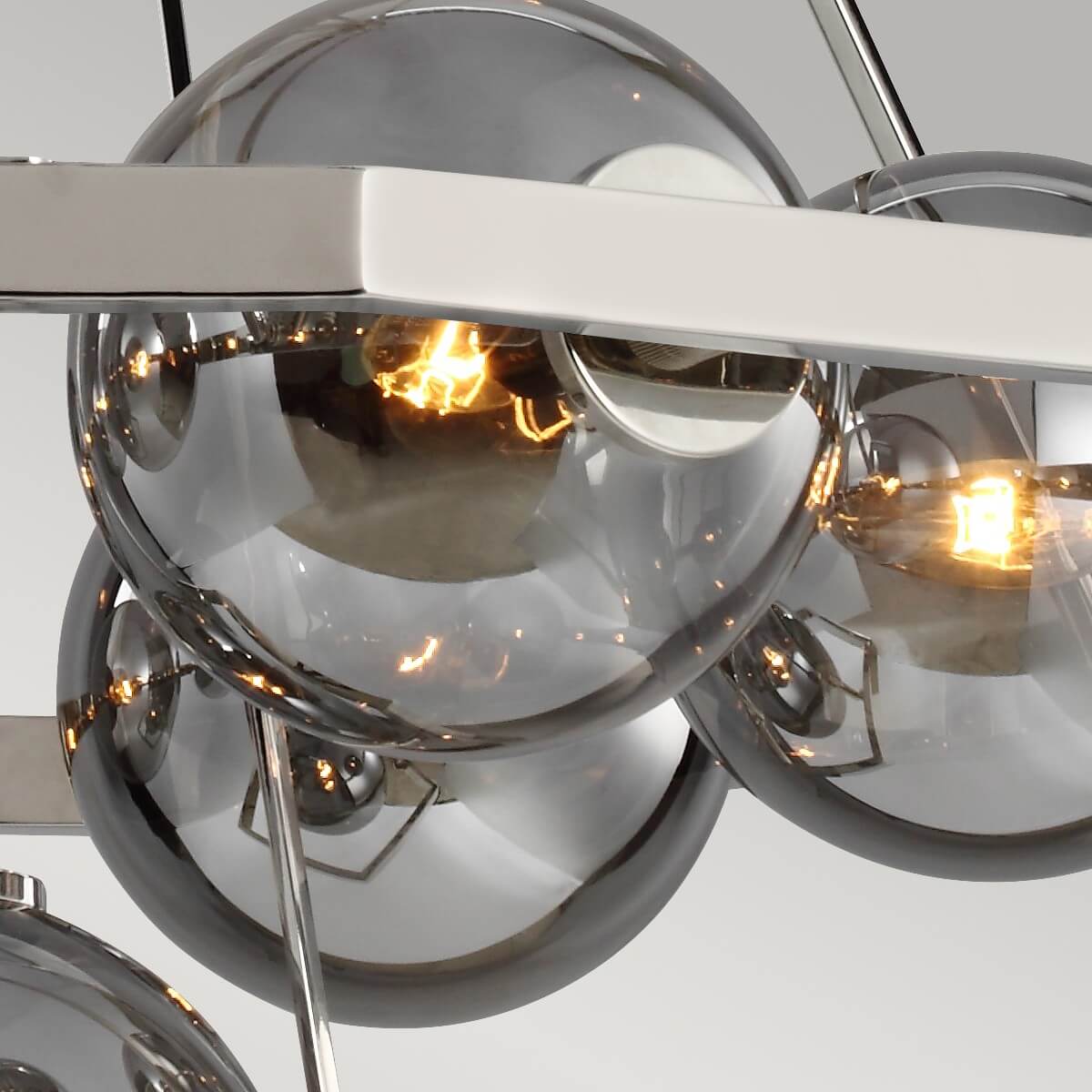 Détail rapproché des globes de verre fumé et de leurs ampoules dorées allumées