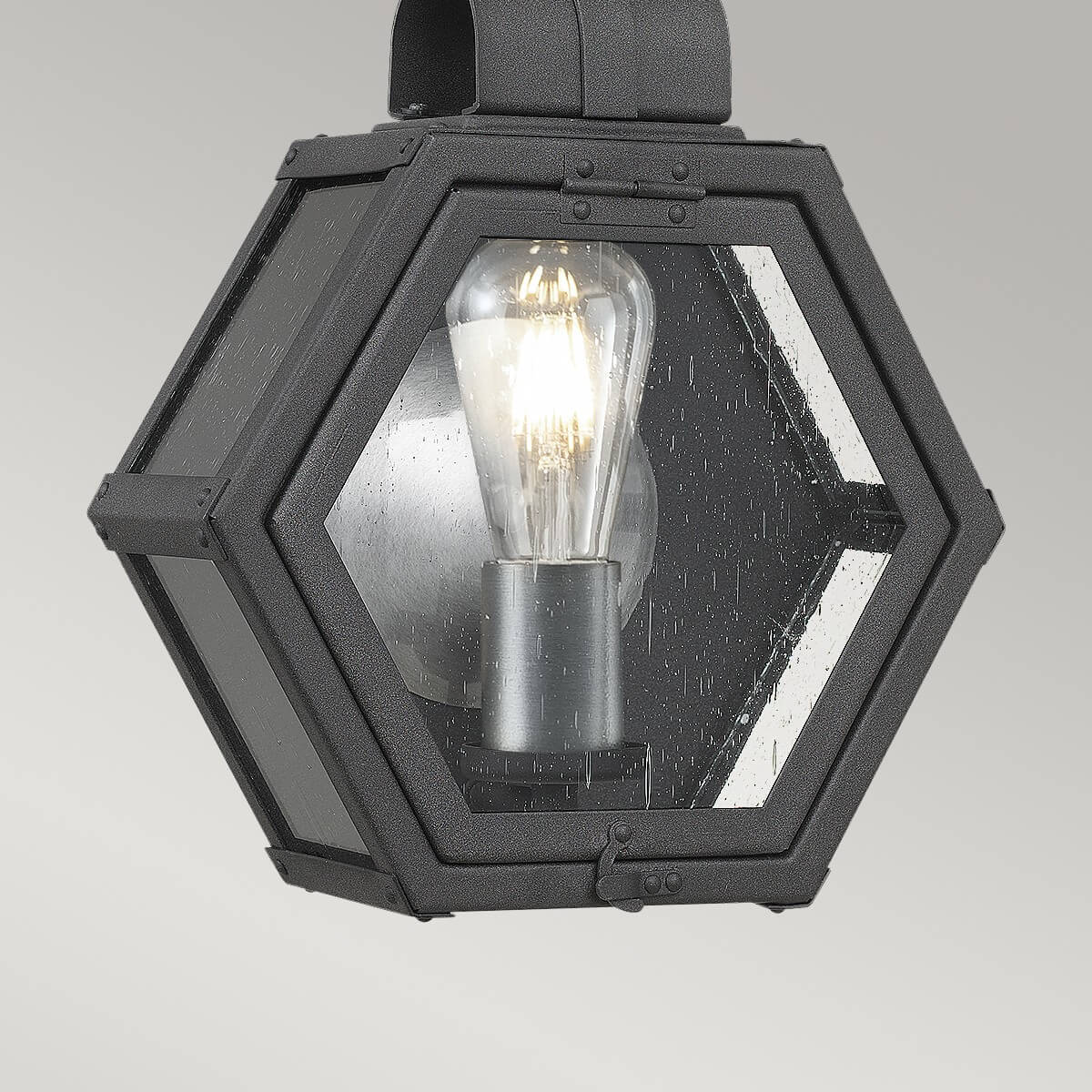 Gros plan sur la façade hexagonale, ampoule Edison et verre transparent moucheté