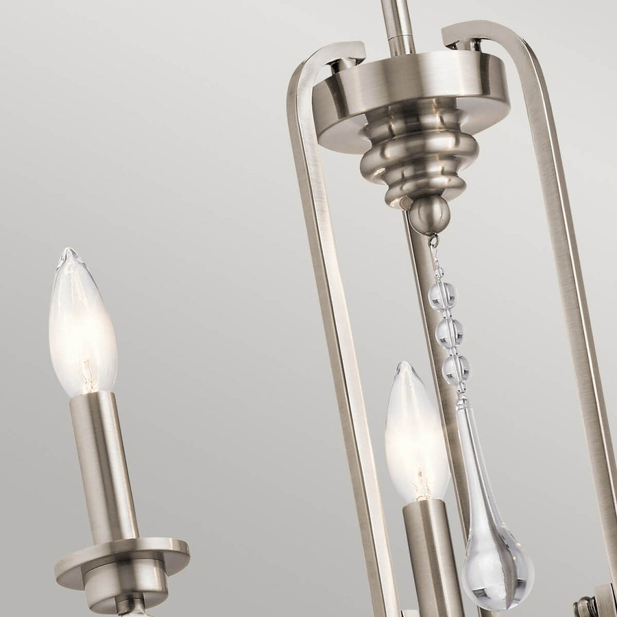 Détail des bras métalliques, douilles bougies allumées et pendants de cristal goutte d'eau