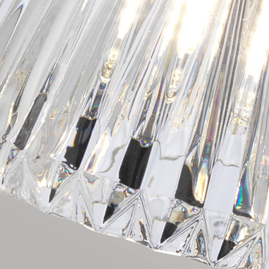 Gros plan du verre moulé strié et de ses reflets irisés sous la lumière