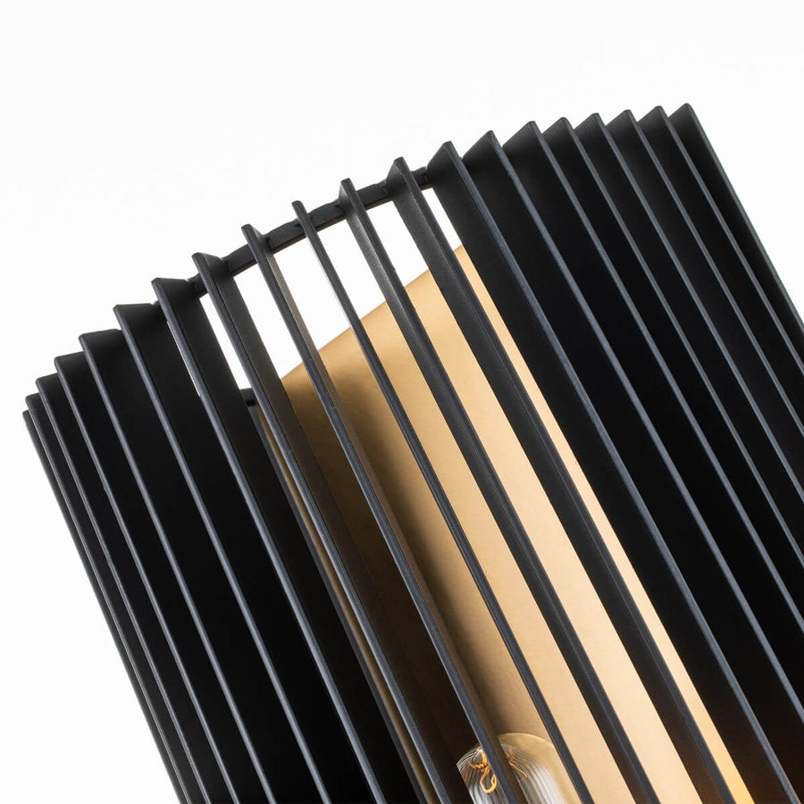 Détail des lamelles noires incurvées et du panneau doré réfléchissant la lumière