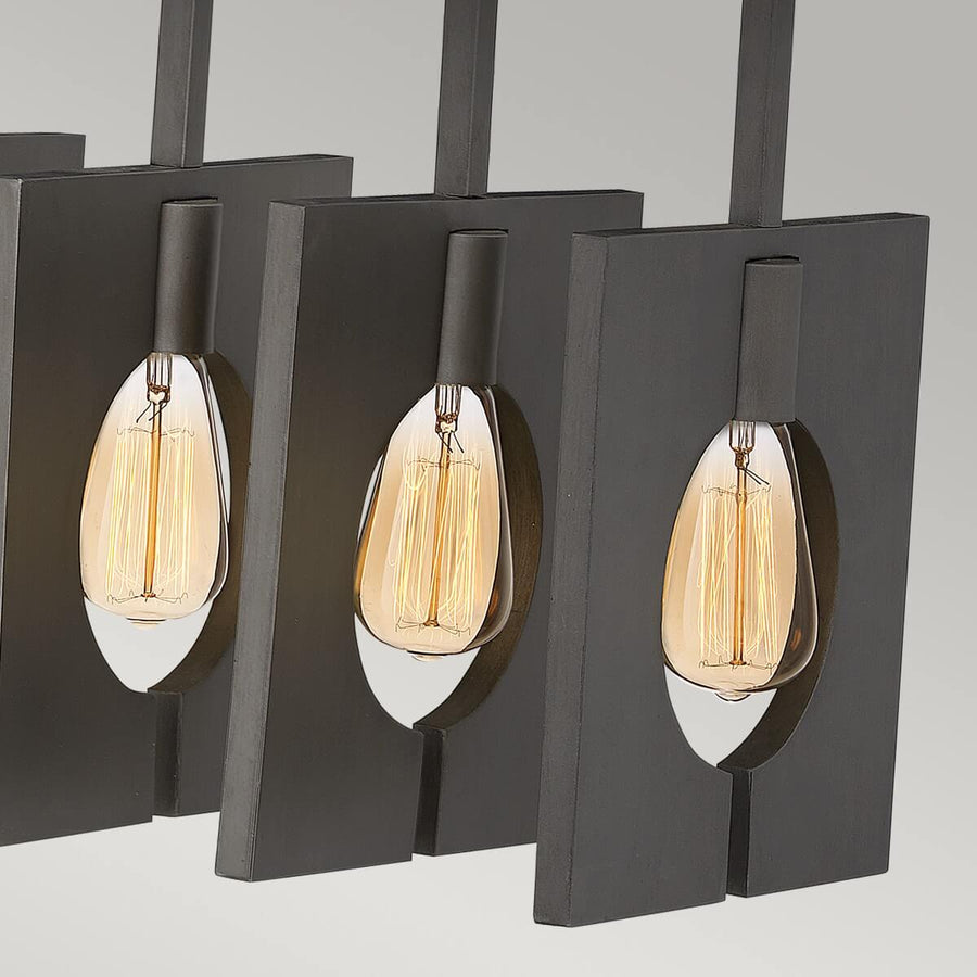 Gros plan sur trois cadres carrés anthracite et leurs ampoules Edison allumées, détail de la finition.