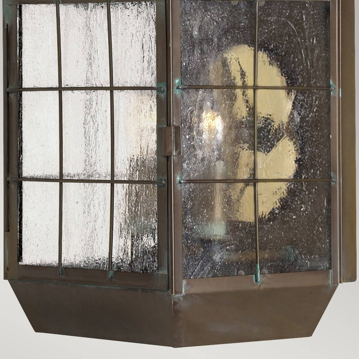 Vue rapprochée du bas de la lanterne et reflet chaud à travers le verre texturé