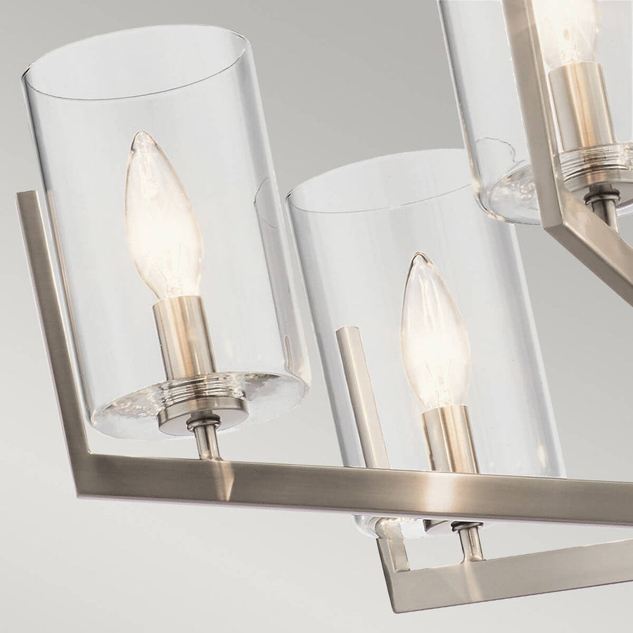 Détail de deux abat-jours cylindriques mettant en valeur la transparence du verre et les ampoules allumées.