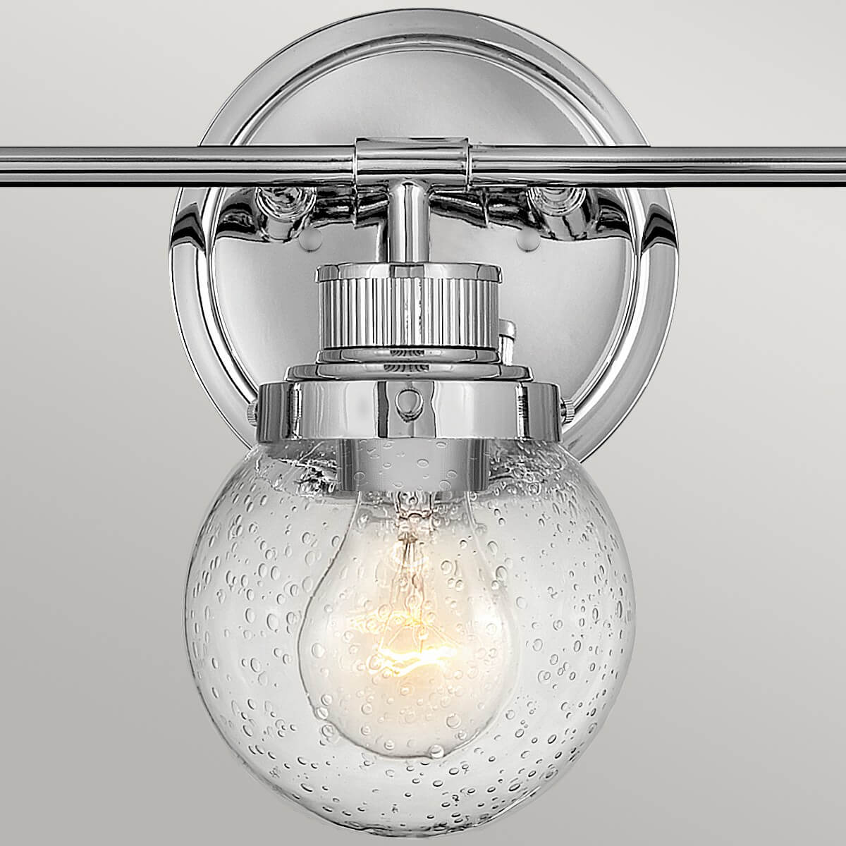Gros plan sur la fixation murale ronde et le support métallique chromé du luminaire