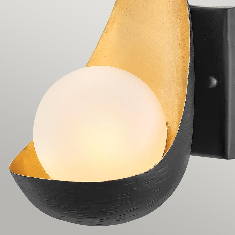 Vue rapprochée du globe lumineux et de la texture martelée de la coque noire.