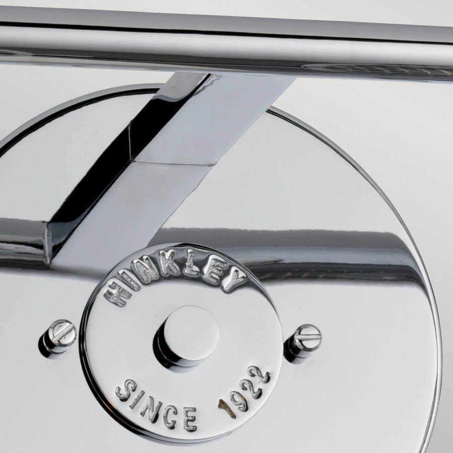 Détail de la platine murale ronde et du bras chromé avec vis de fixation