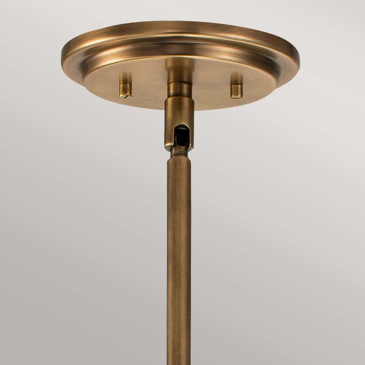 Détail de la rosace ronde en laiton fixée au plafond avec ses vis apparentes