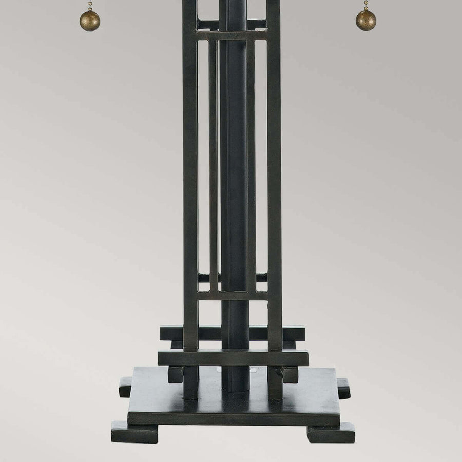 Détail du pied géométrique en métal bronze et des tirants latéraux de la lampe.