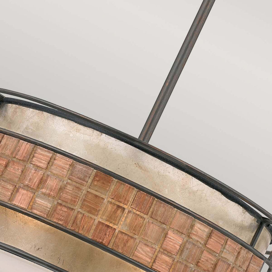 Gros plan incliné sur la frise de carreaux mosaïque cuivrée et cerclage métal