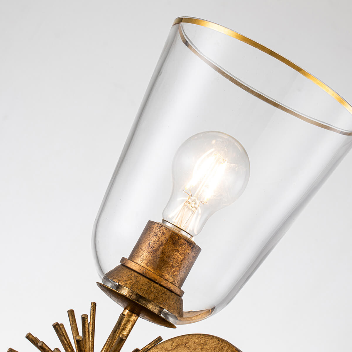 Gros plan sur l'abat-jour en verre transparent et son liseré doré