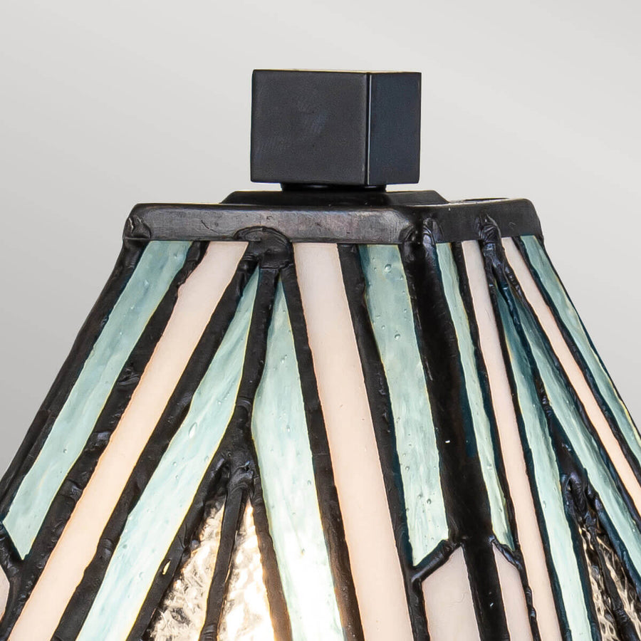 Détail du sommet : petit cube noir posé sur l'abat-jour en verre