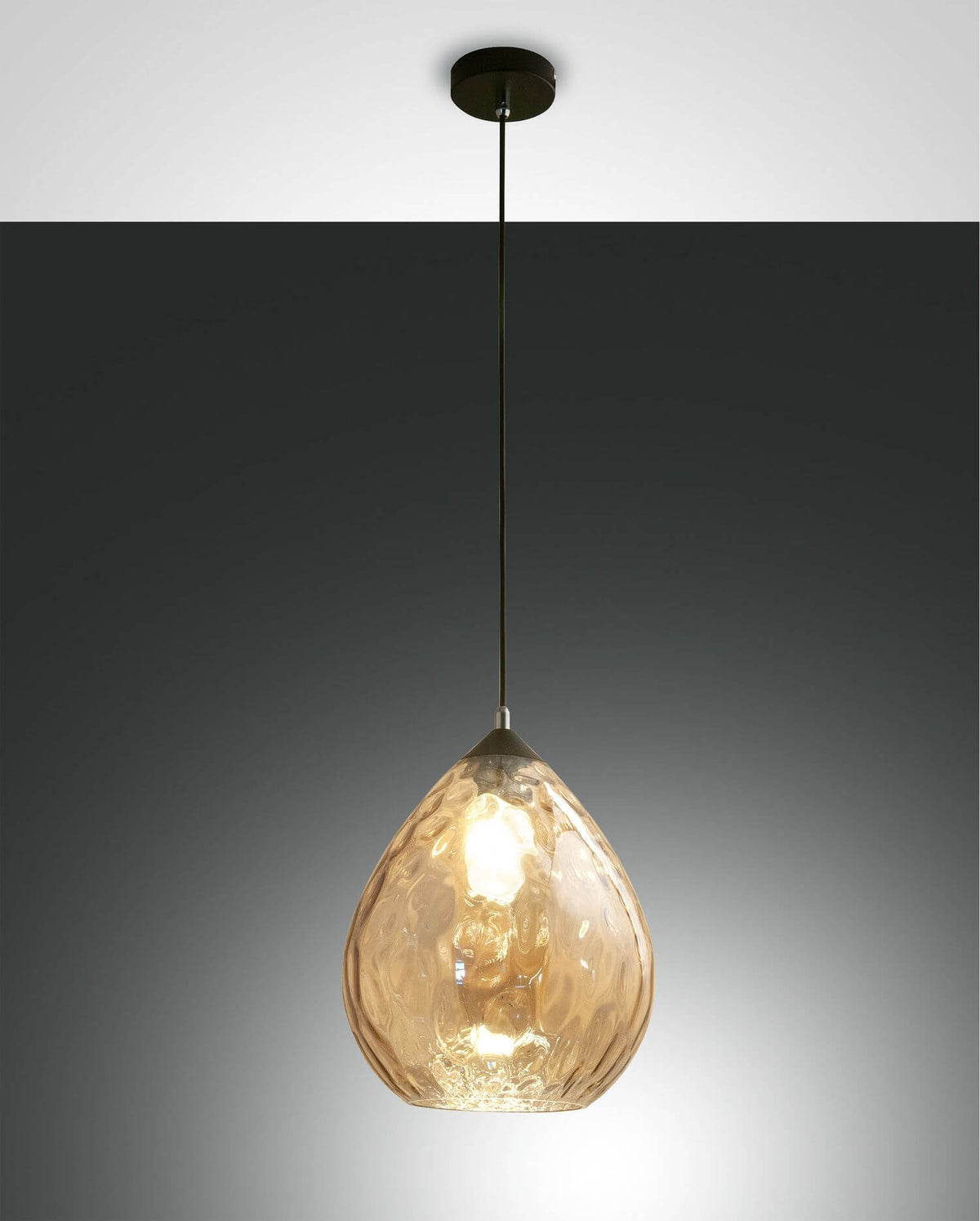 Suspension ambrée en verre martelé allumée sur fond gris anthracite