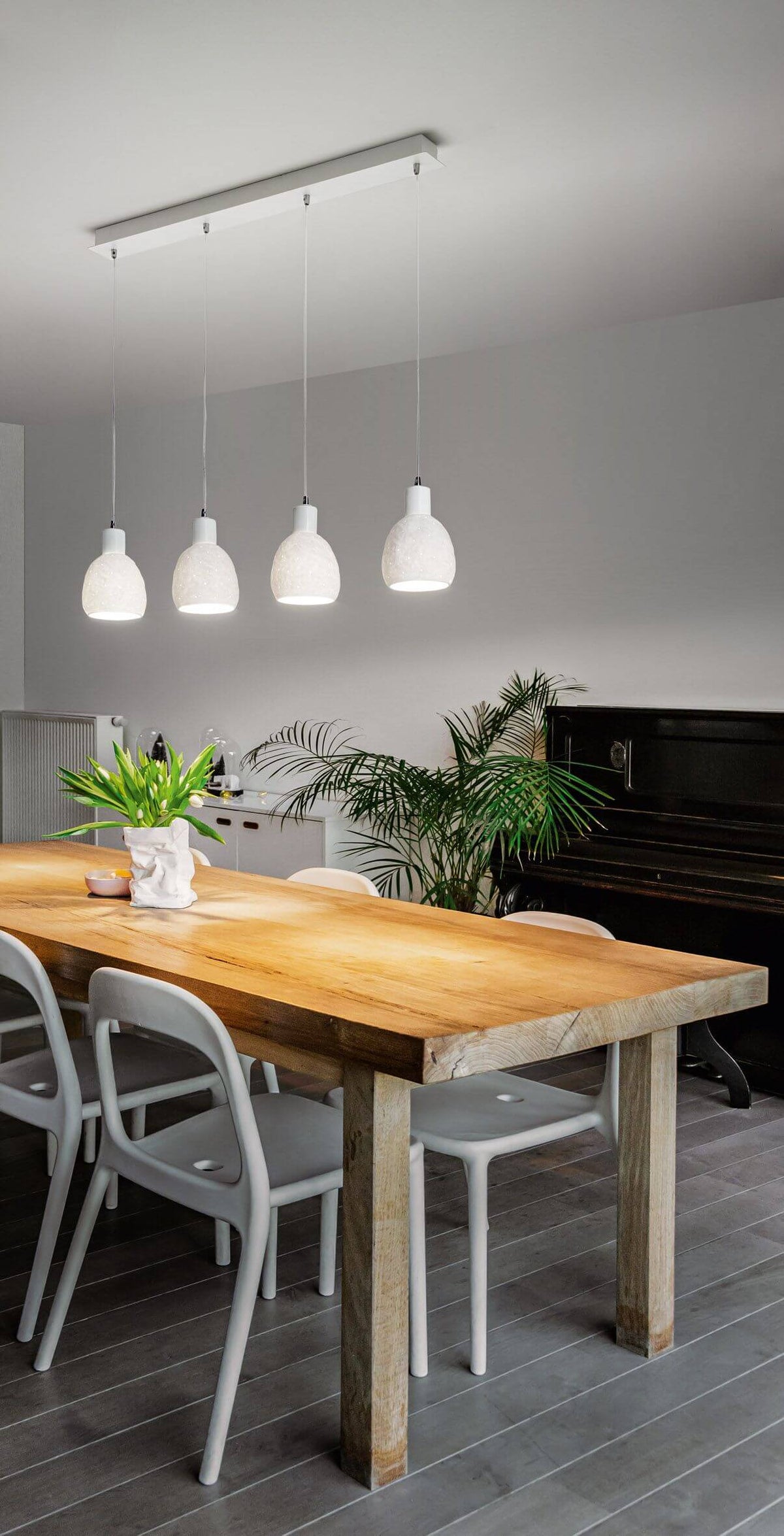 Vue en situation au-dessus d'une table en bois, suspension allumée dans une salle à manger