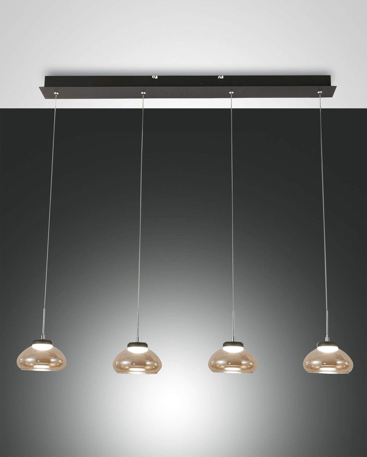 Vue de face du luminaire suspendu avec quatre abat-jours en verre ambré alignés.