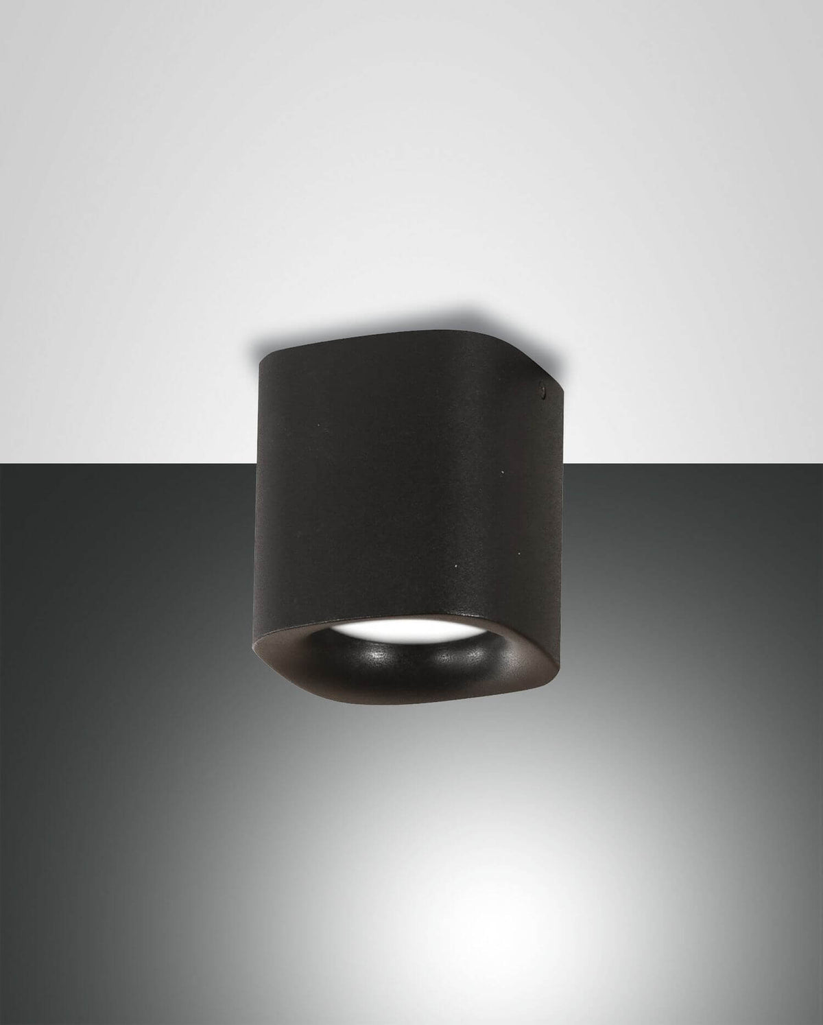 Projecteur noir cylindrique fixé au plafond, éclairant vers le bas, vu de face