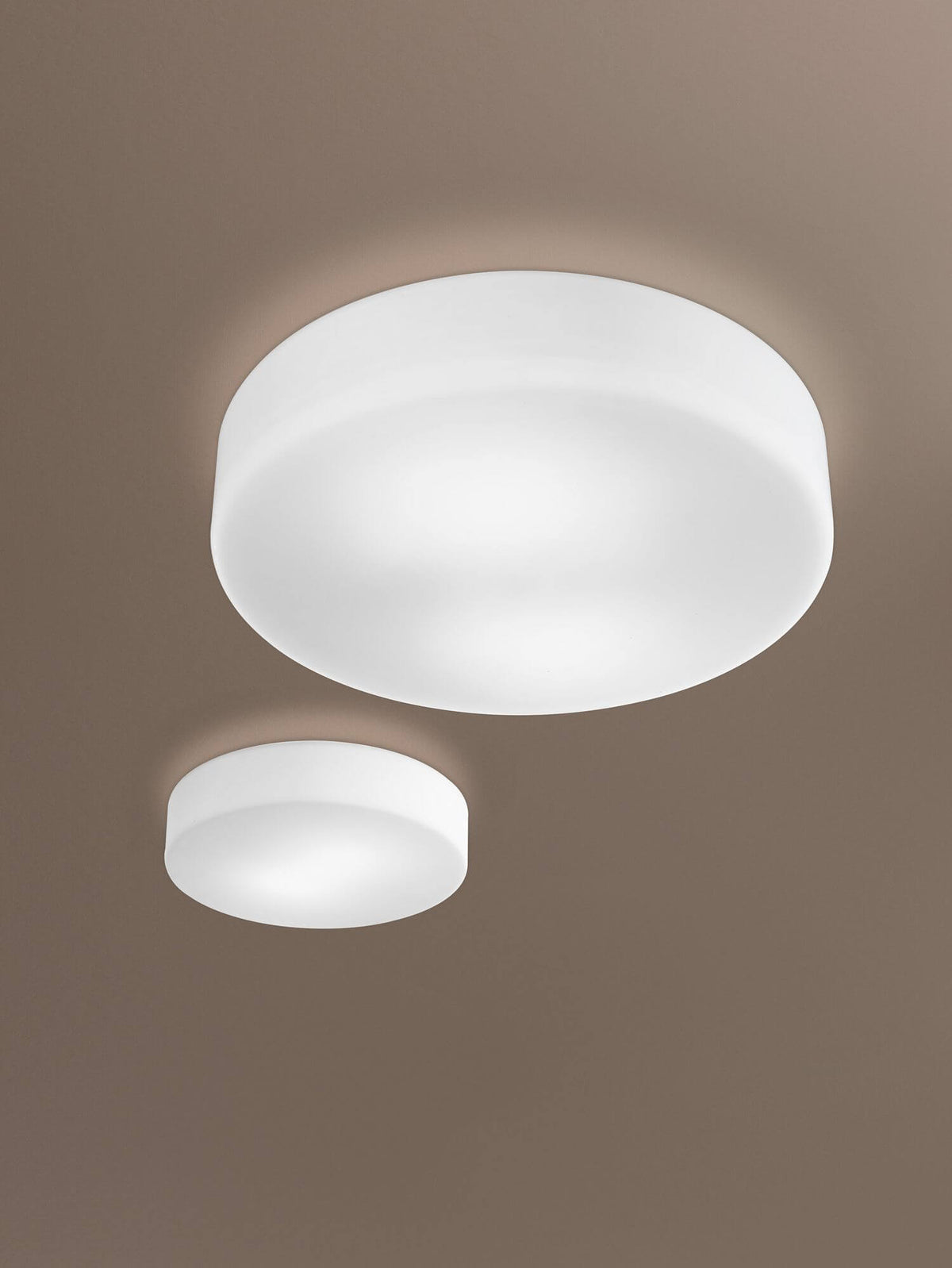Deux plafonniers cylindriques blancs allumés fixés au plafond, mise en ambiance chaleureuse