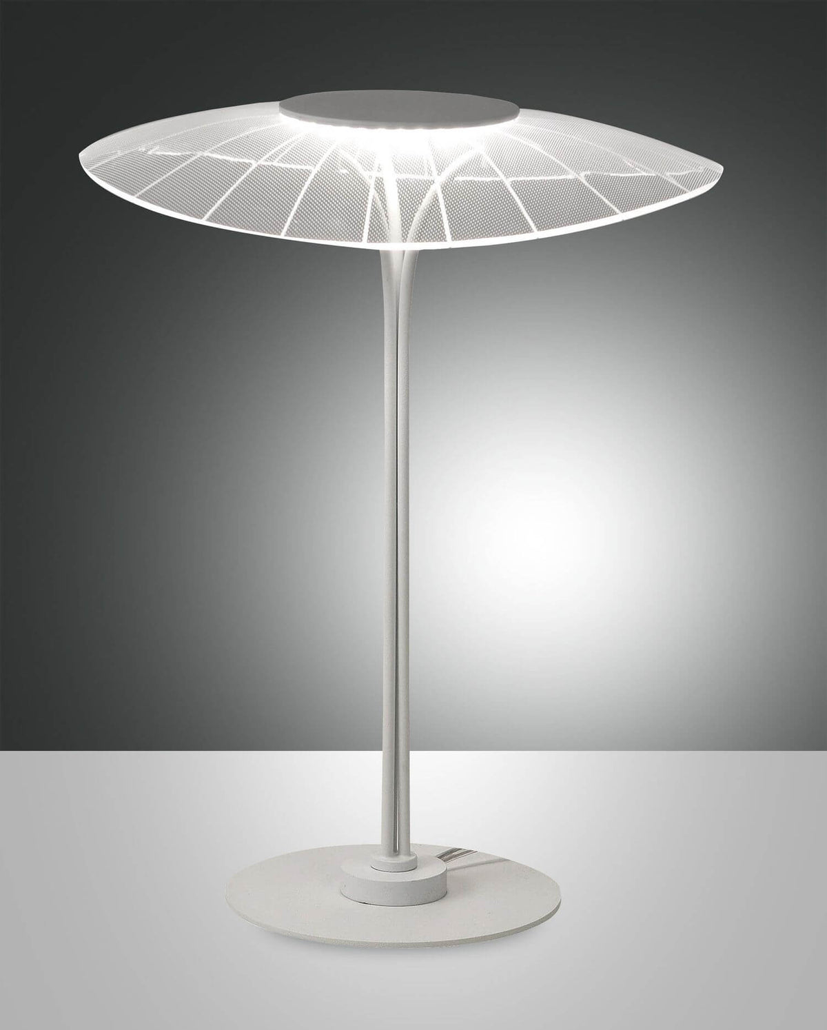 Lampe blanche de face sur fond gris, abat-jour tulle illuminé et socle rond