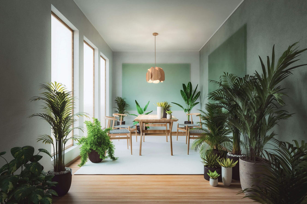 Lampe suspendue dans un intérieur végétalisé, grandes plantes vertes et lumière naturelle
