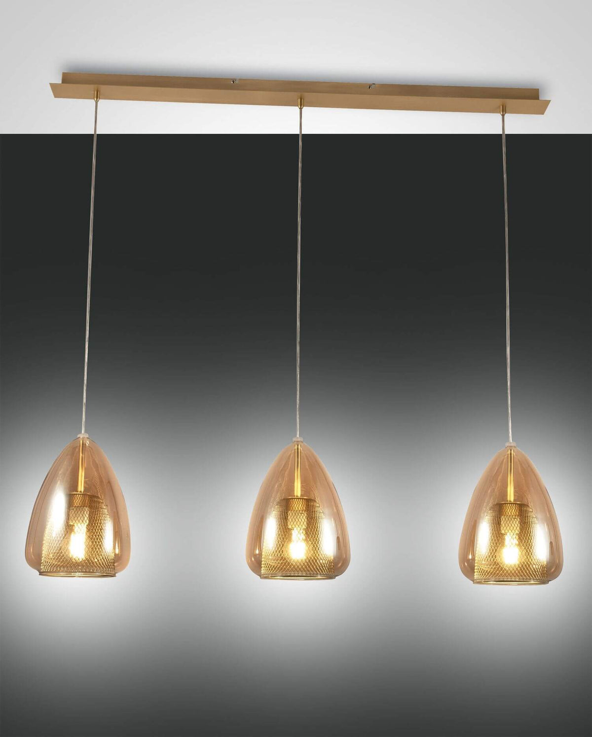 Suspension à trois lumières en verre ambré et finition dorée sur fond sombre.