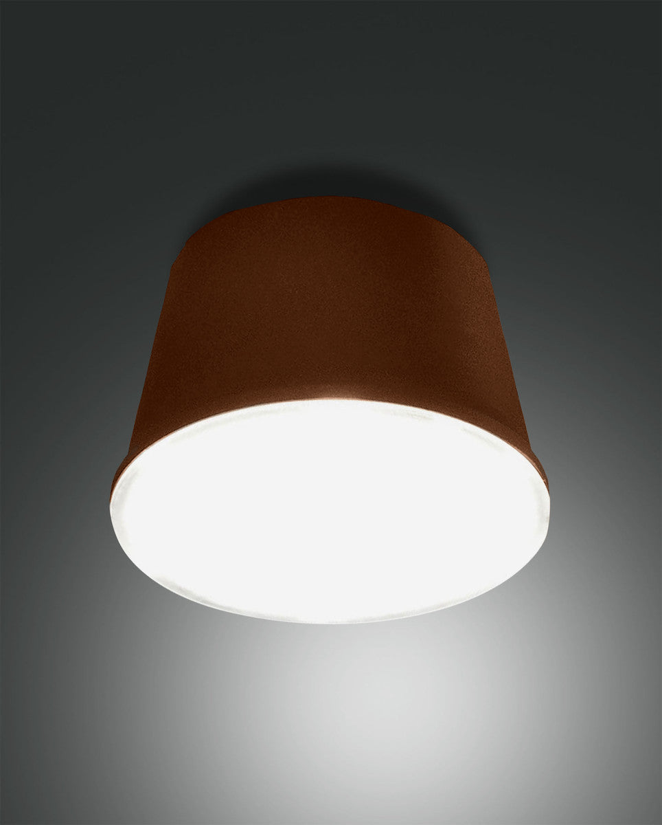 Vue de dessous du projecteur allumé, halo lumineux diffus sur fond gris sombre