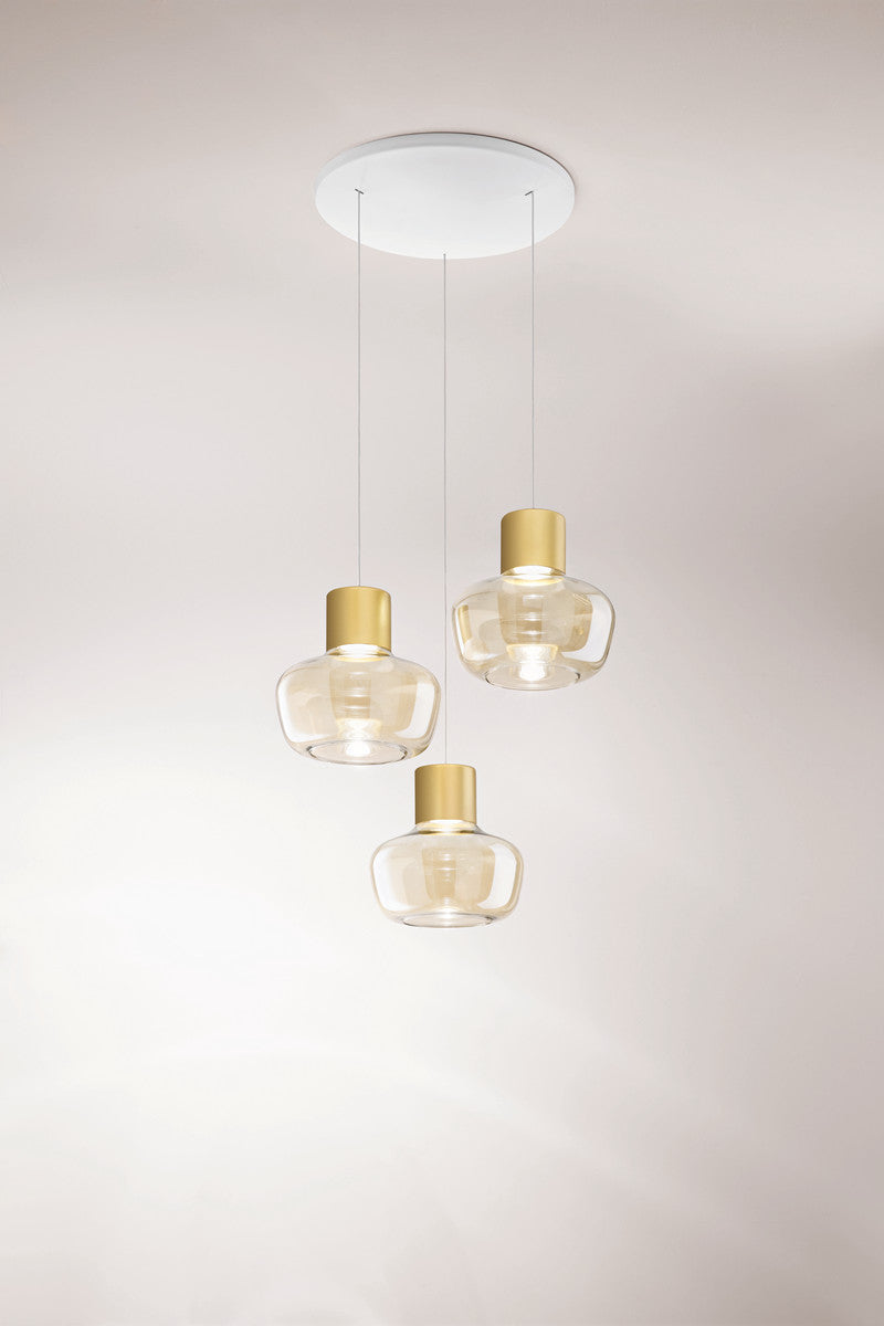 Trois globes en verre clair suspendus par de fins câbles sous un pavillon blanc
