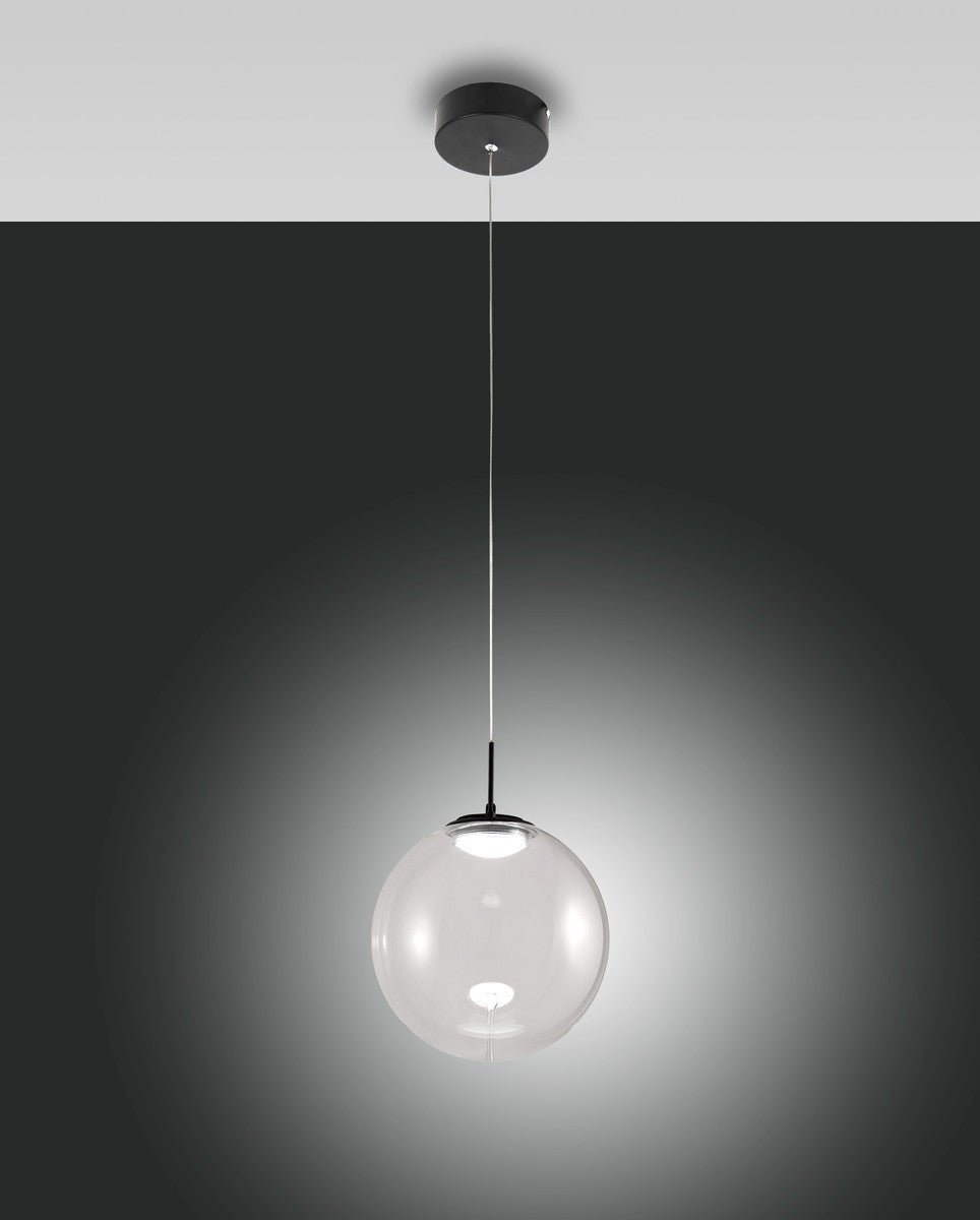 Suspension à globe de verre transparent allumé, vue de face sur fond gris dégradé