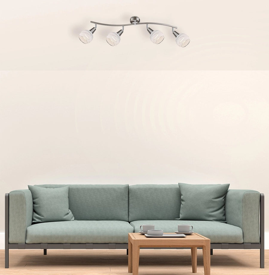 Plafonnier fixé au plafond dans un séjour, au-dessus d'un canapé vert et table basse.