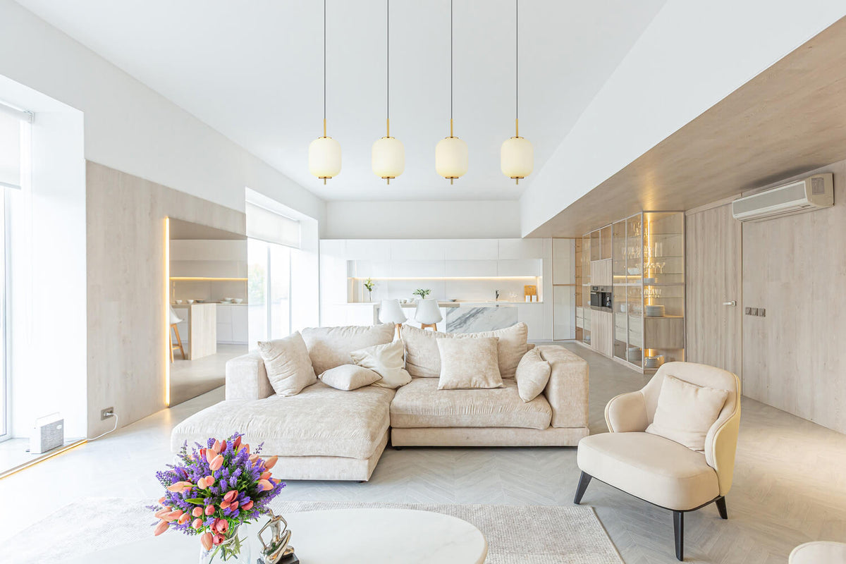 Mise en ambiance dans un salon contemporain clair, suspension au-dessus du canapé beige