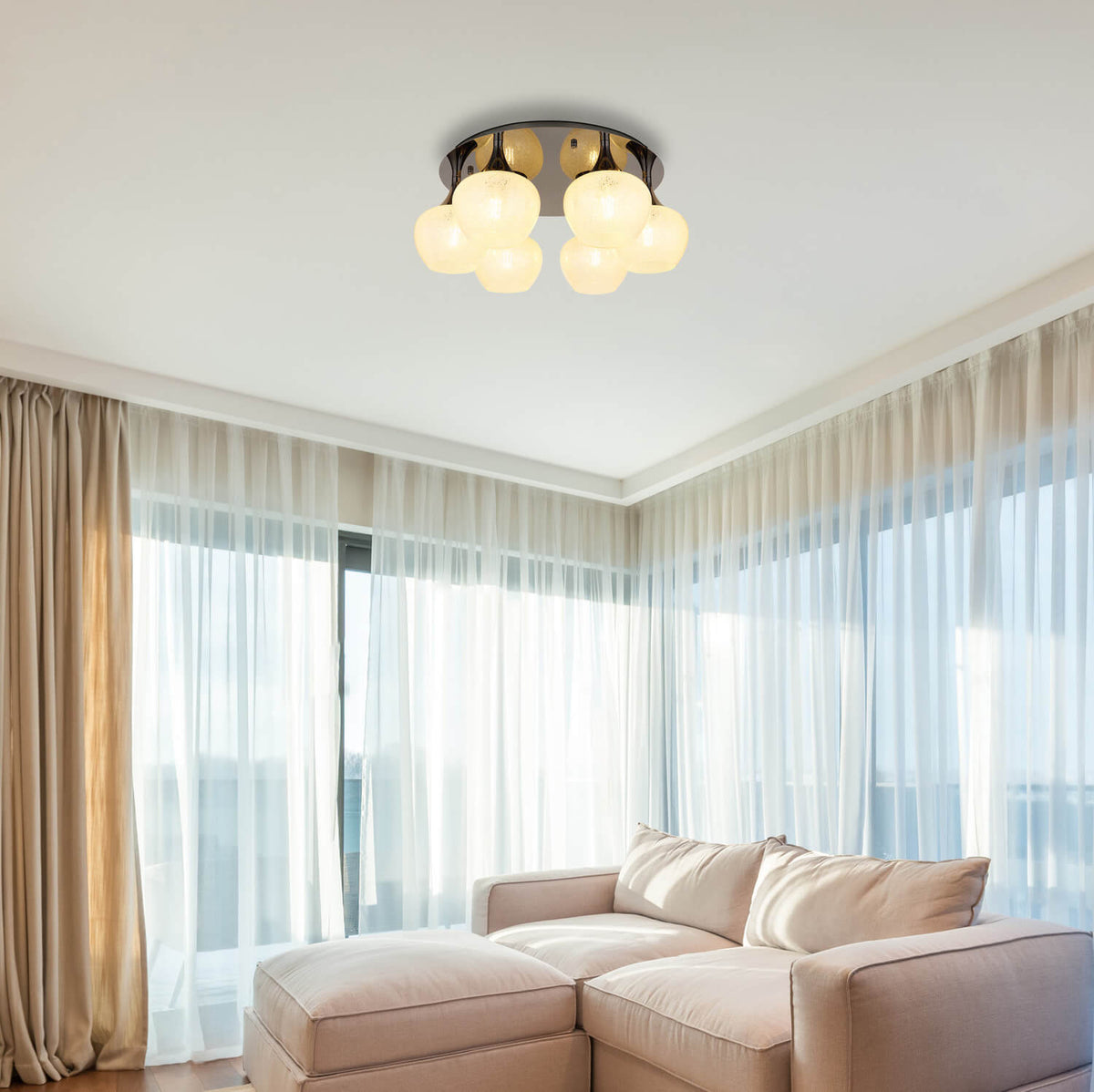 Mise en ambiance dans un salon, plafonnier allumé au-dessus d'un canapé beige