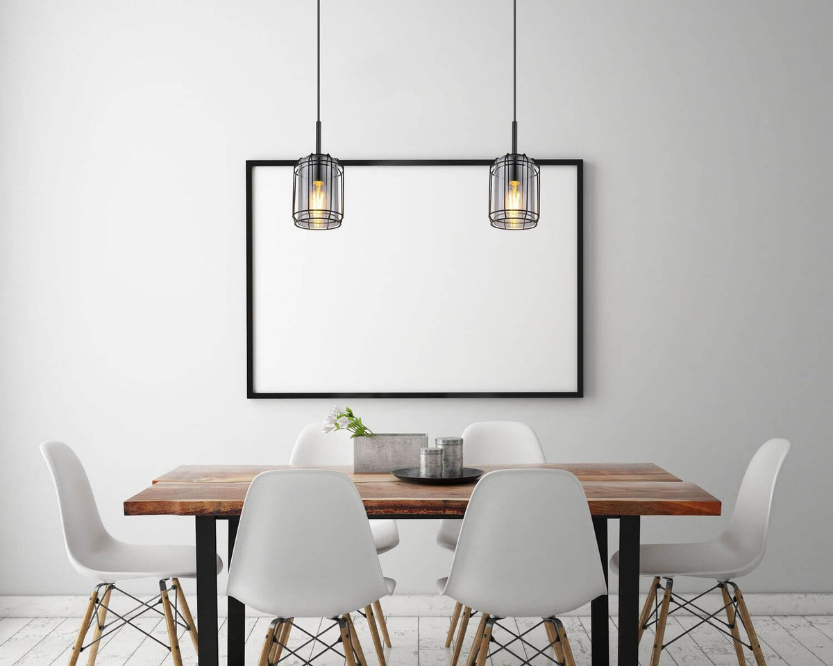 Mise en ambiance de deux suspensions au-dessus d'une table à manger en bois.