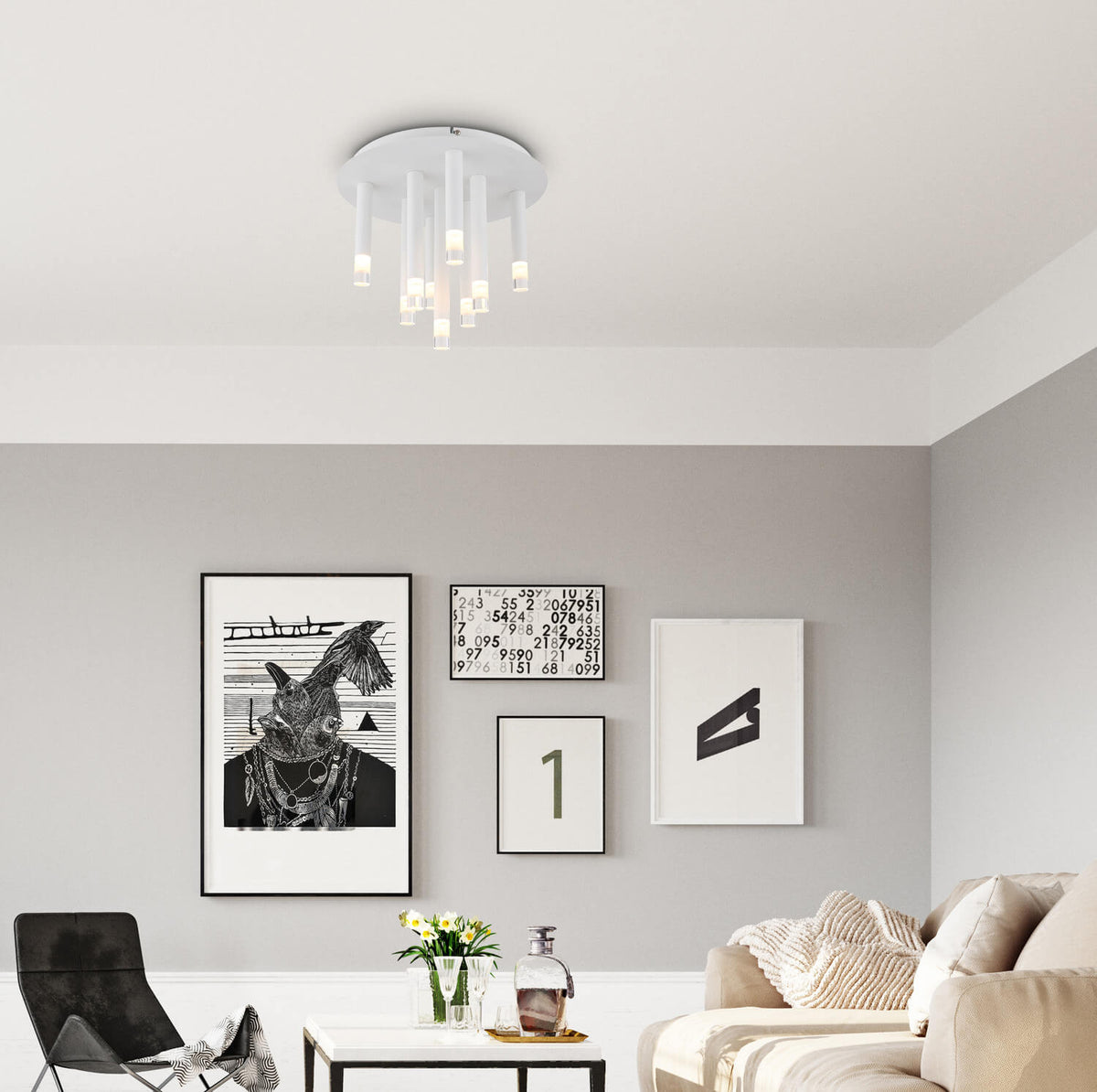 Mise en ambiance dans un salon gris clair avec canapé beige et cadres noirs