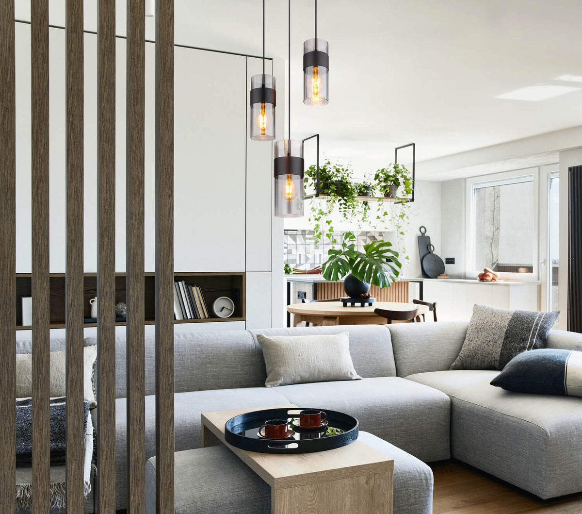 Mise en ambiance du séjour : suspension au-dessus du canapé gris et table basse