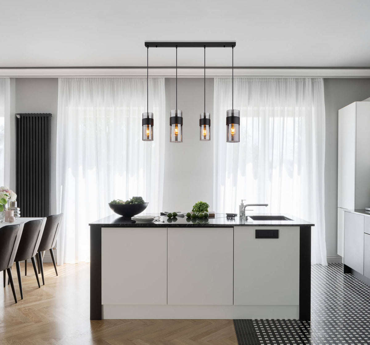 Mise en ambiance au-dessus d'un îlot de cuisine moderne, suspension allumée dans un intérieur clair