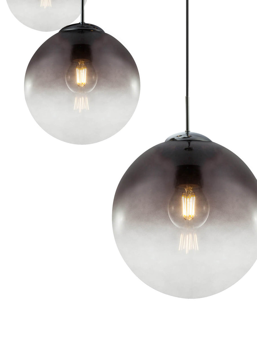 Gros plan sur deux globes en verre dégradé et leur ampoule filament