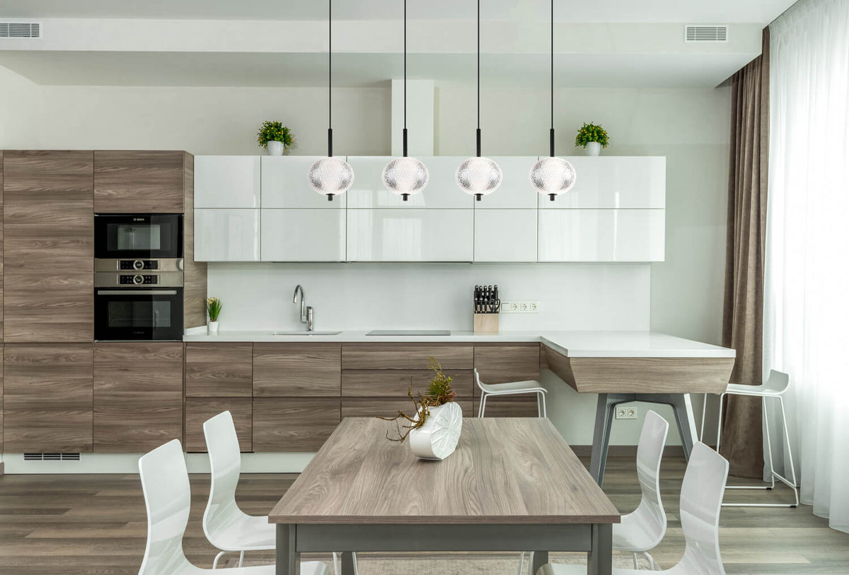 Mise en ambiance d'une cuisine moderne, luminaire allumé au-dessus de la table